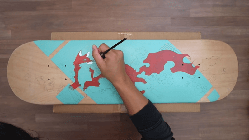 drawing a red fox pattern on skateboard deck