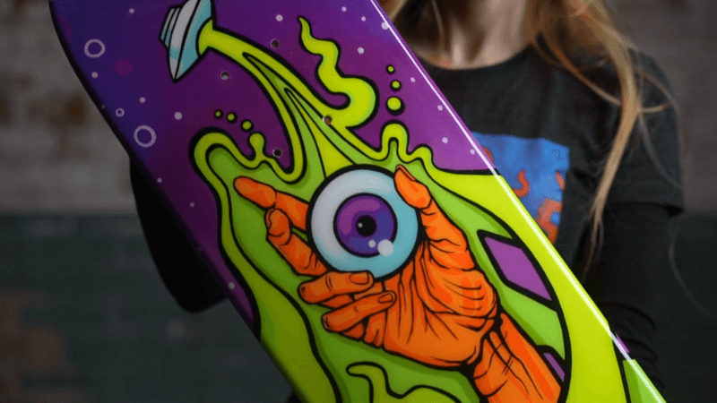 girl holding an alien personalized skateboard deck